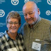 Two alumni getting their picture taken.